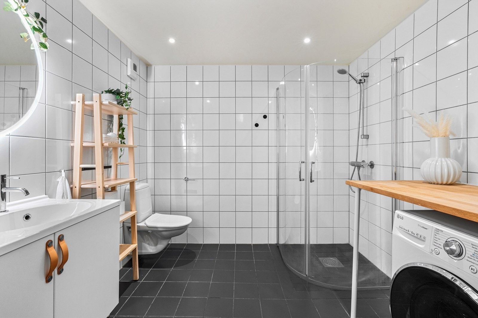 Leiligheten har et romslig bad med flislagte overflater og gulvvarme. Galleribilde