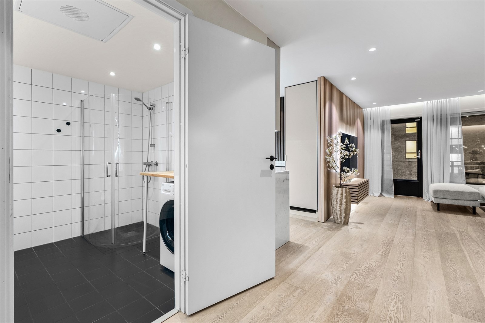 Badet har dusjhjørne med dusjdører, gulvmontert toalett og downlights i himlingen. Galleribilde