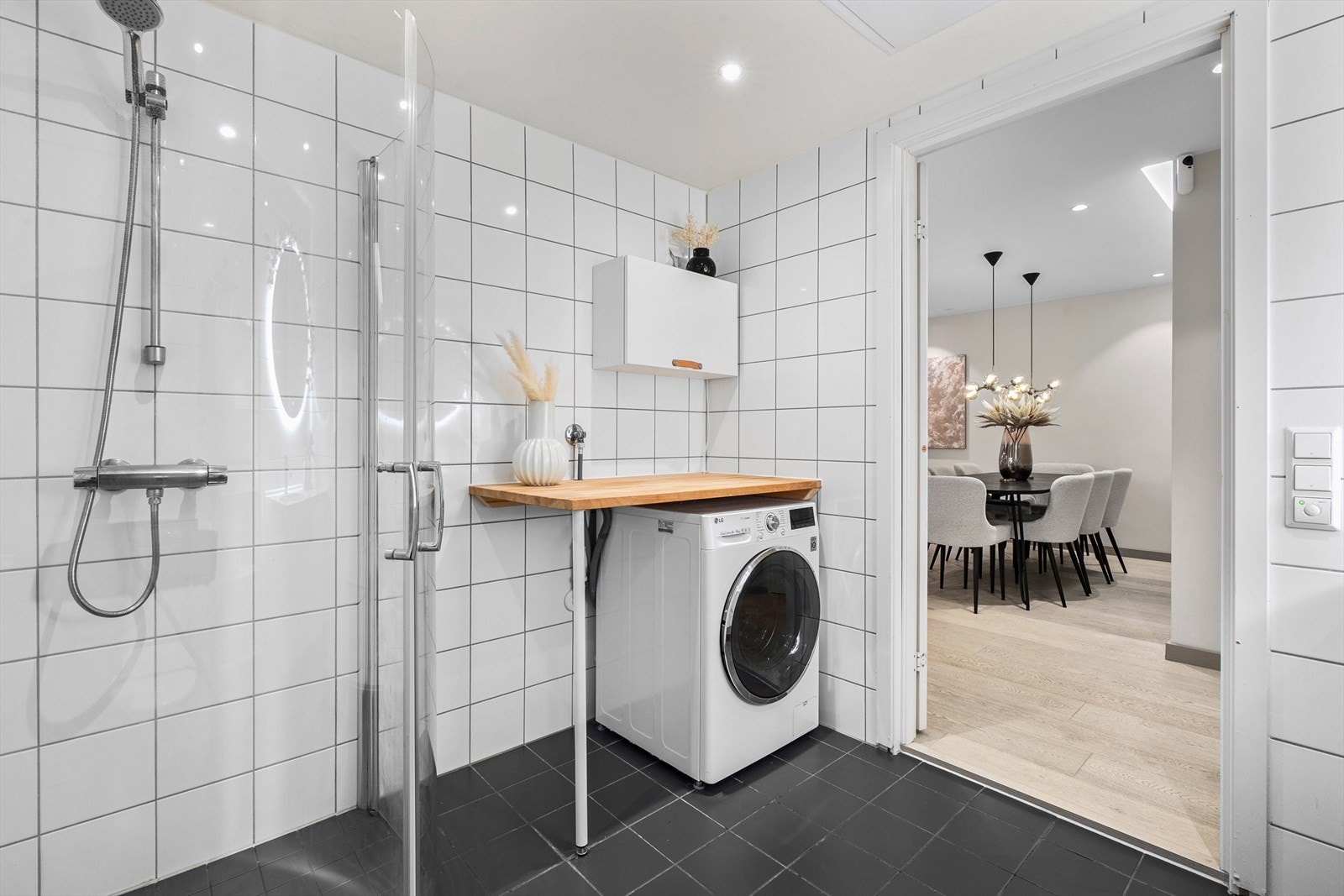 Det er opplegg for vaskemaskin under en kjekk arbeidsbenk og over er det skap med plass til vaskemidler og annet. Galleribilde