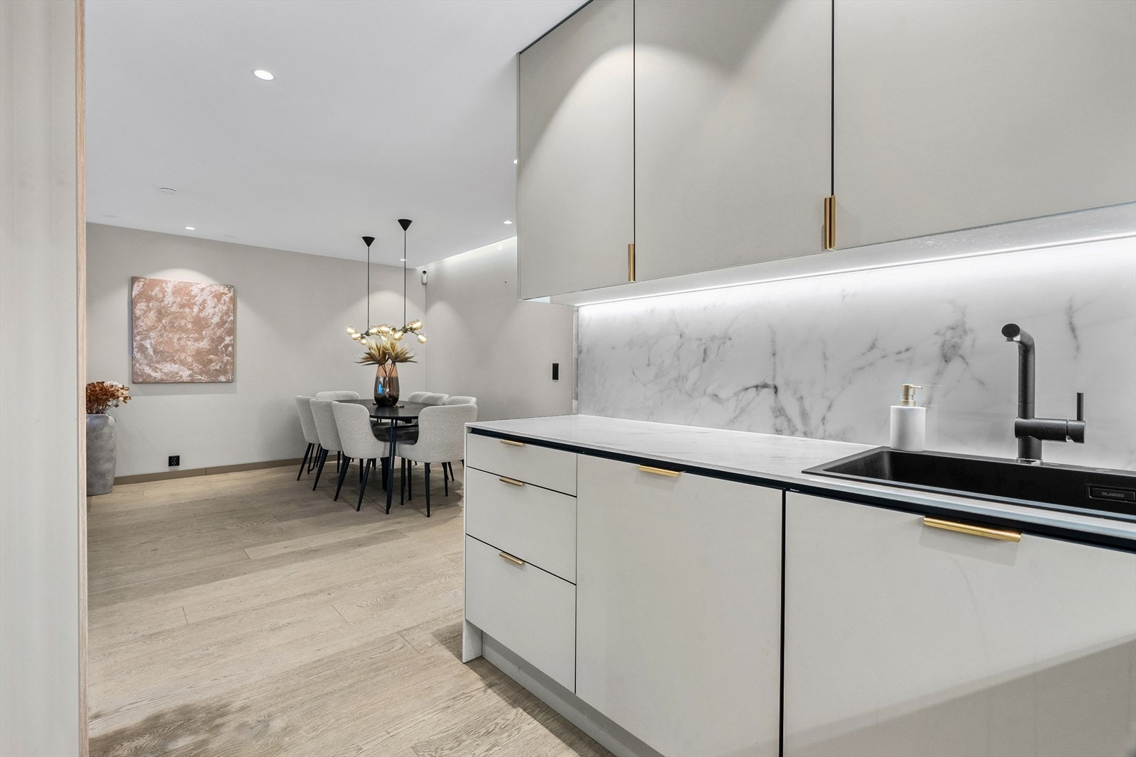 Både dekkside, kjøkkenbenk, vegger over benken er dekket med marmormønstrede, keramiske plater. Galleribilde