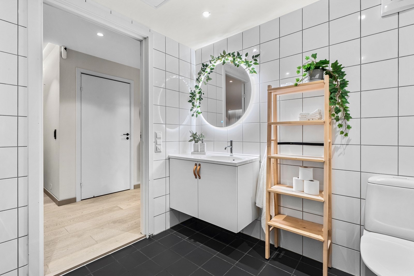 Baderomsinnredningen har heldekkende servant og et rundt speil med integrert belysning. Galleribilde