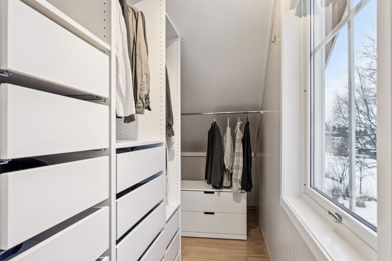 Skjult bak en skyvedør har hovedsoverommet et walk-in closet med skuffer, hyller og stenger for oppheng. Galleribilde