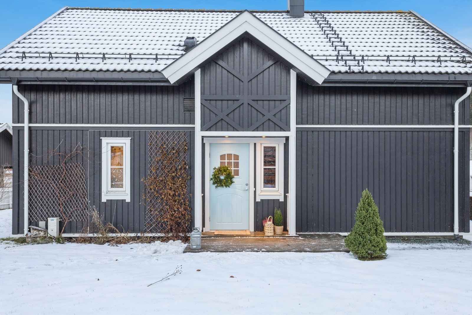 Ved inngangen er det en liten terrasse, og begge uteplassene på bakkeplan ble oppført i 2014 og beiset i 2023. Galleribilde