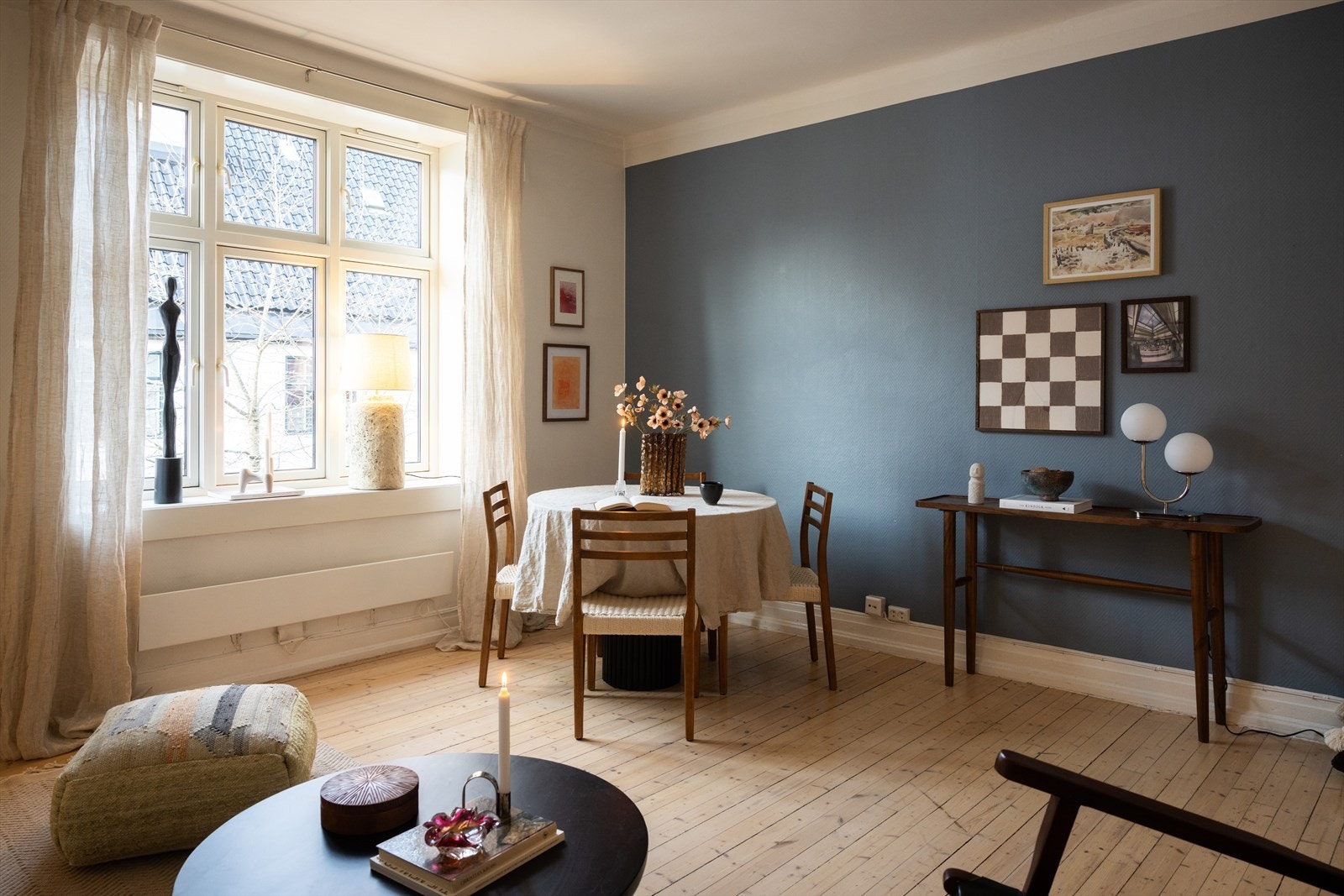 En lys og romslig stue med god plass til sofa, stuebord, spisebord og stoler, samt annet møblement Galleribilde