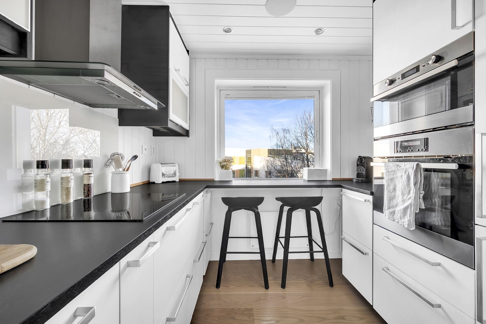 Det er glassplater på vegg over induksjonstopp og oppvaskkum. Galleribilde