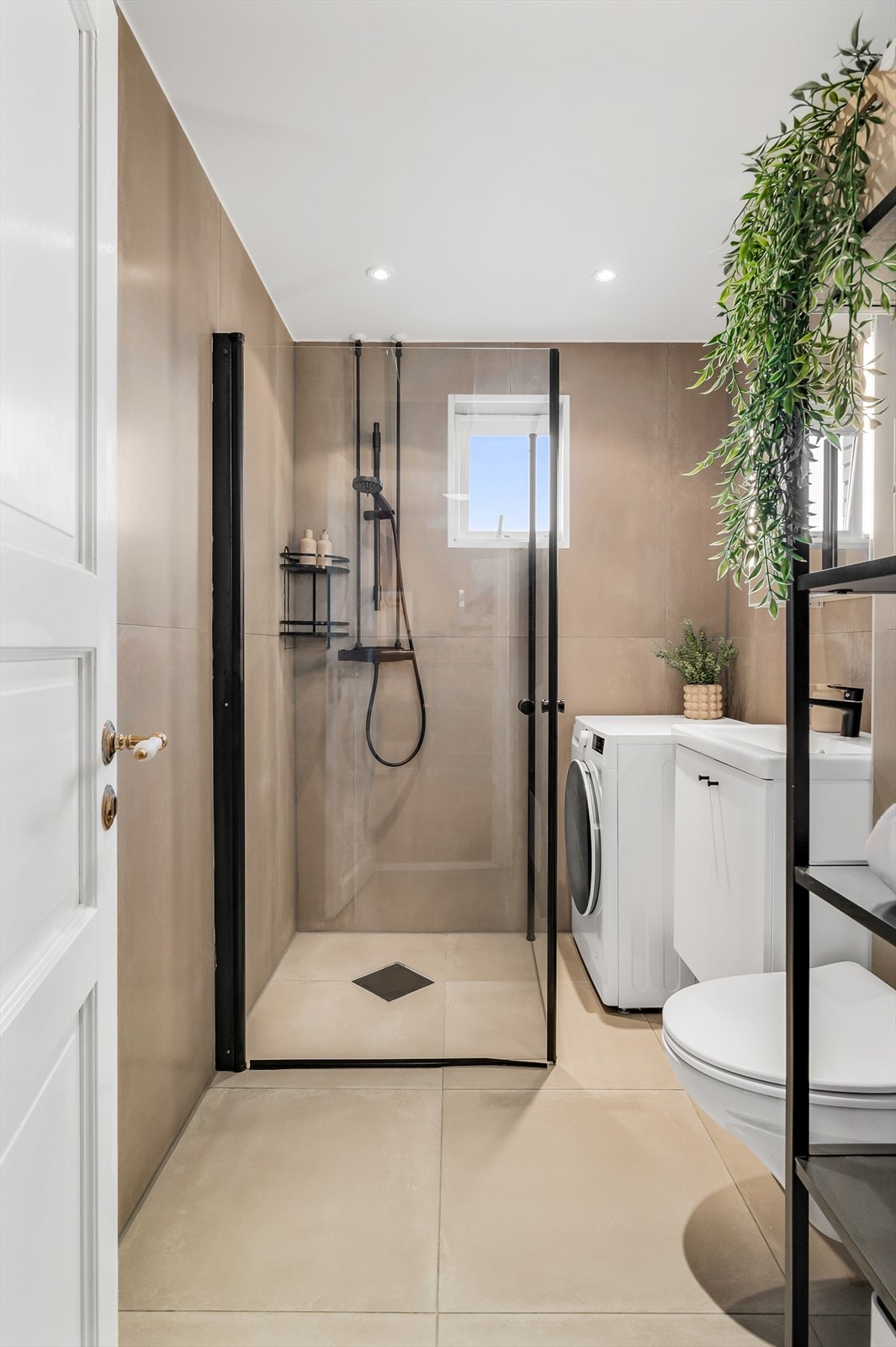 Lekkert bad med delikate flis og gulvvarme. Moderne dusjnisje med sorte detaljer på armatur og glassdører. Galleribilde