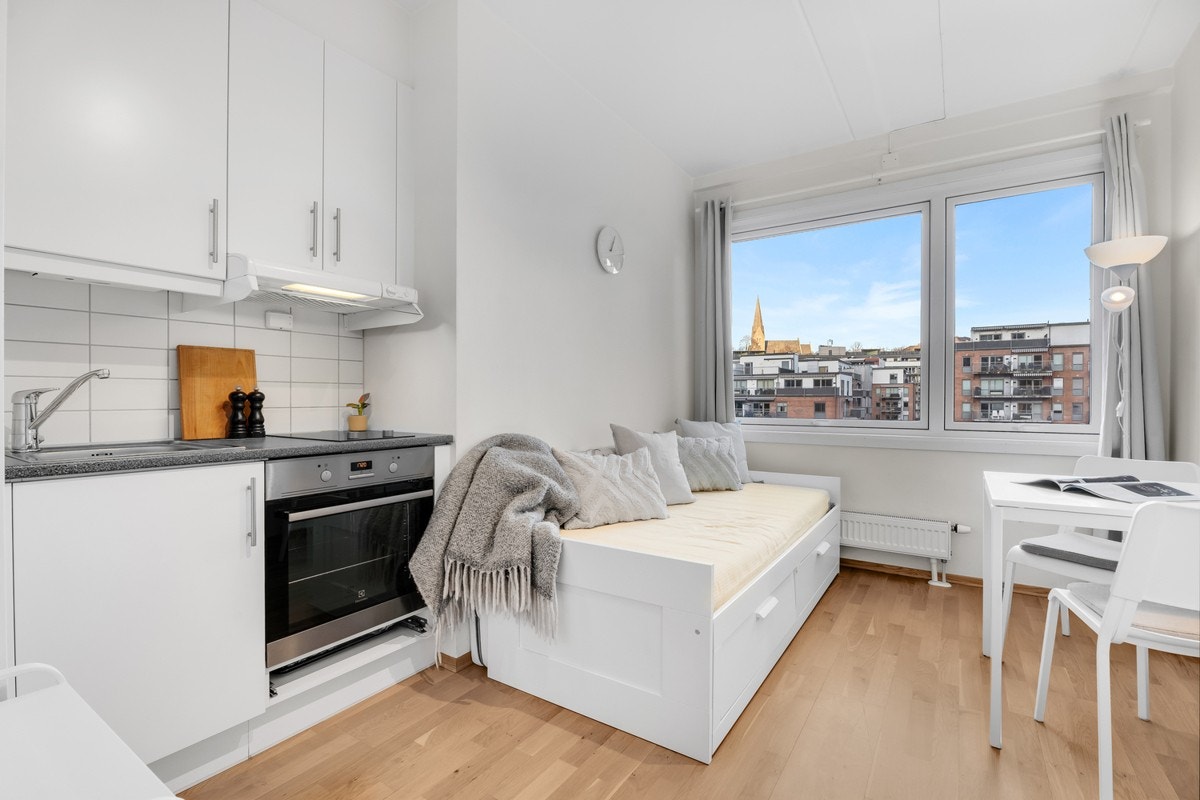 Hybelen har kjøkkeninnredning fra 2015 med glatte lyse fronter Galleribilde