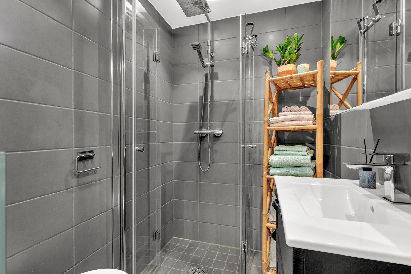 Badet består av vegghengt toalett, servant med servantskap, og dushjørne med glassdører. Galleribilde