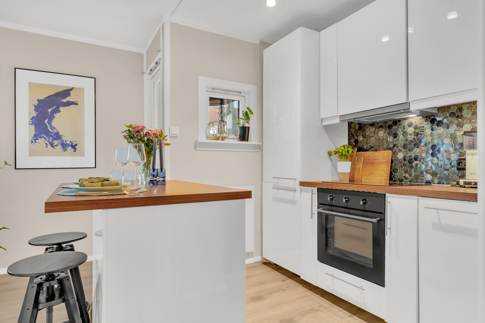 Praktisk kjøkkenøy med sitteplasser/barløsning for ekstra benkeplass og oppbevaring. Kjøkkenøyen er plassert oppå gulvet, slik at den kan fjernes ved ønske. Galleribilde