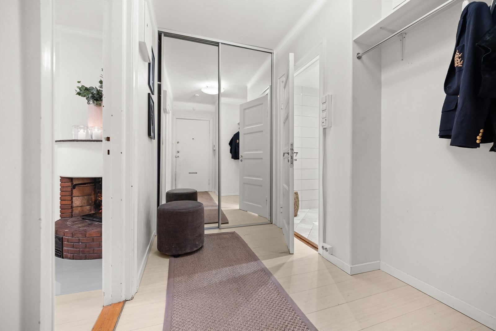 Romslig entré med rikelig plass til klesoppheng og oppbevaring i en praktisk skyvedørsgarderobe med speilfronter. Galleribilde