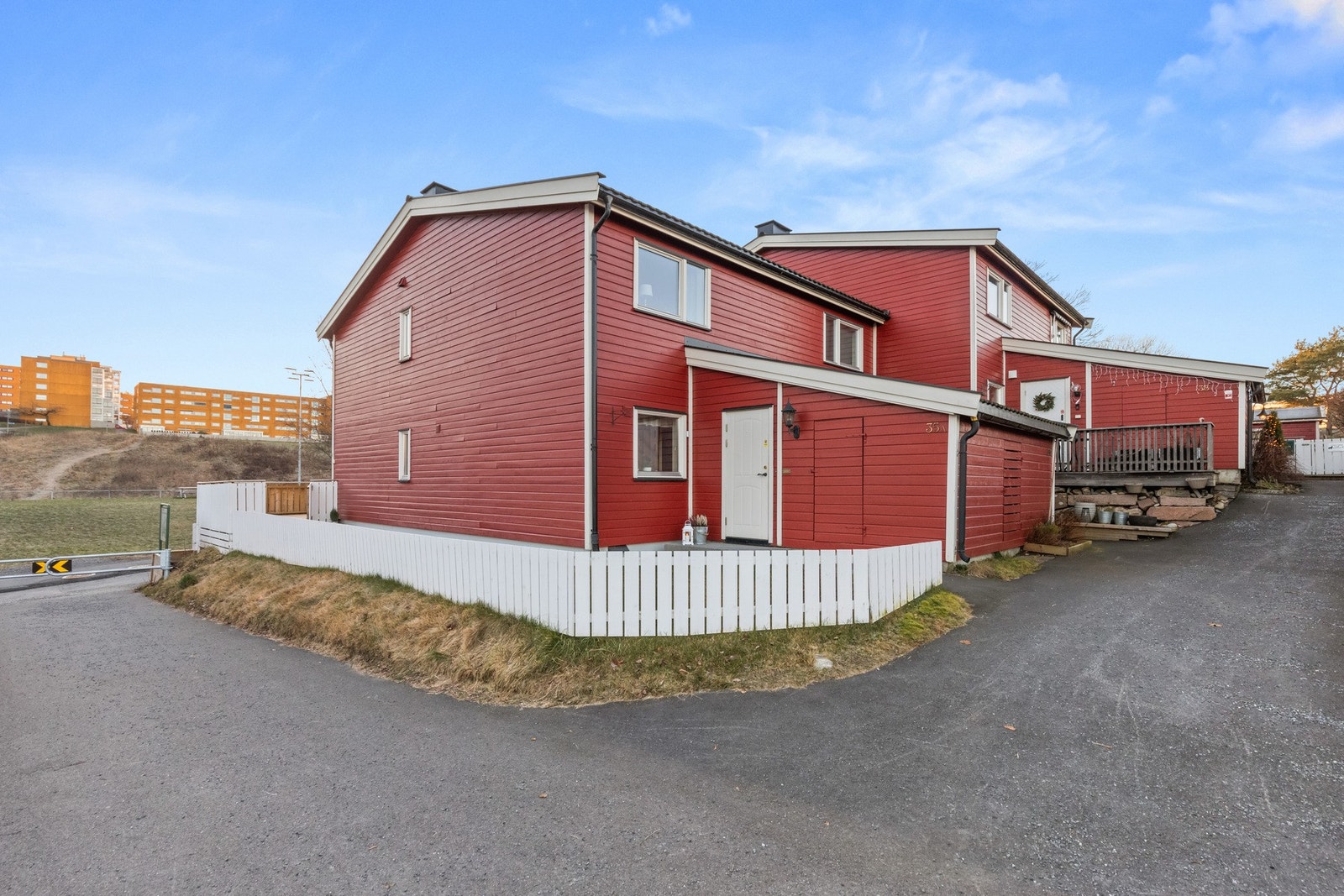 Fasade vist fra inngangspartiet hvor du også har en stor utebod på 5 kvm. Det ble drenert rundt boligen i 2021 og satt opp nytt gjerde. Galleribilde