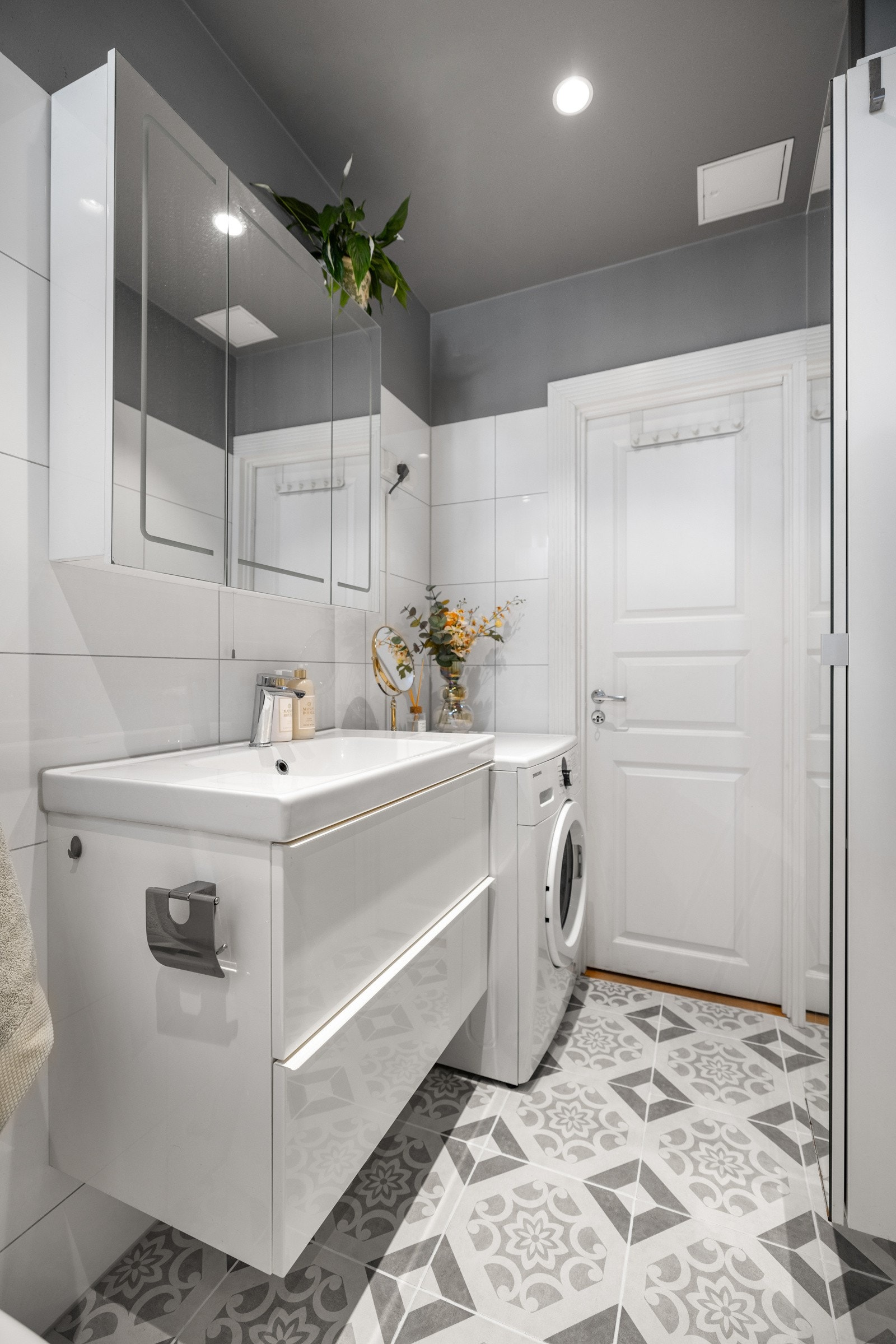 Videre kan badet by på dusj rett på flis, veggmontert servantinnredning, vegghengt speilskap med belysning, stort avlangt speilskap med god plass til oppbevaring og gulvstående klosett Galleribilde