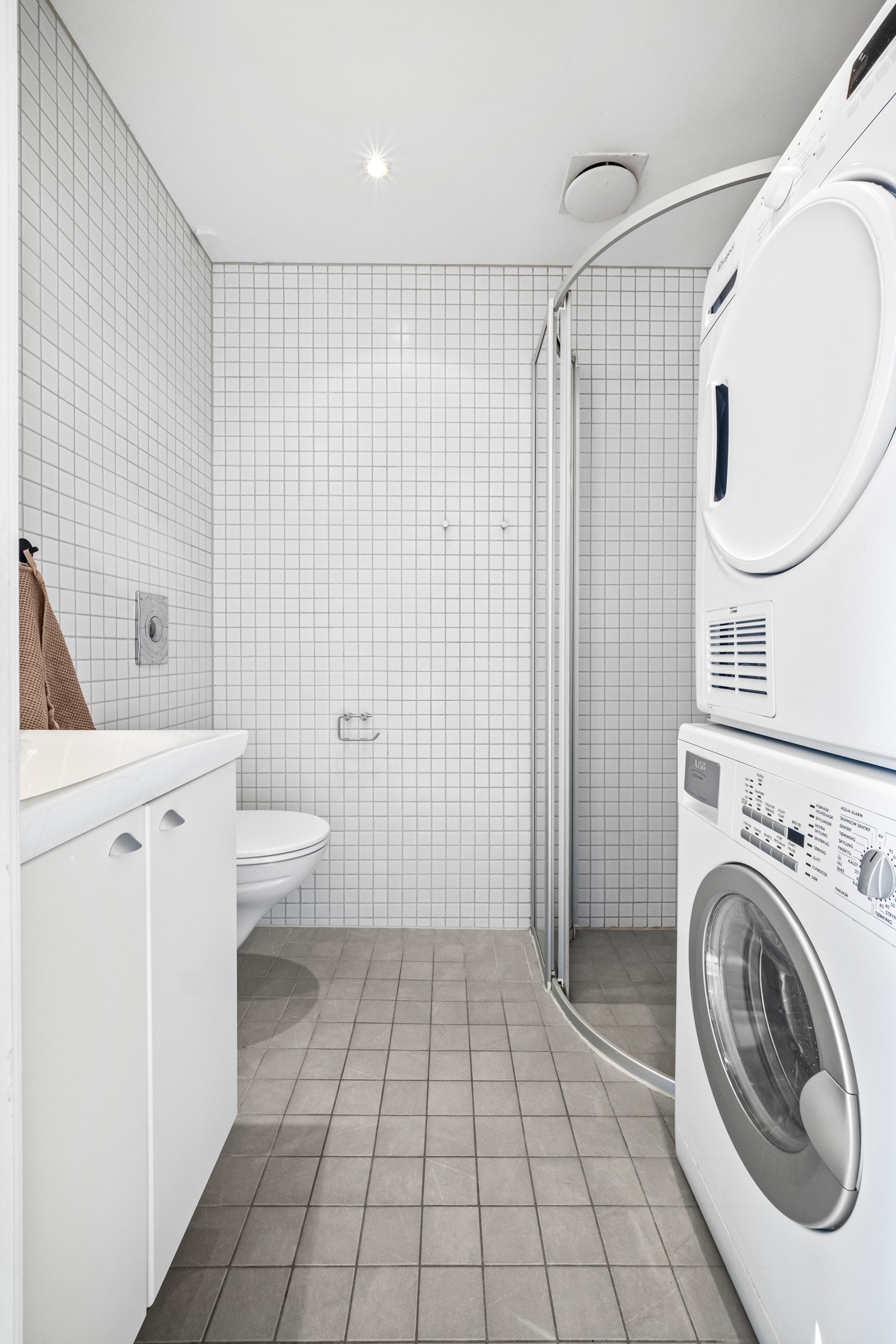 Delikat bad med plass til vaskemaskin og tørketrommel Galleribilde