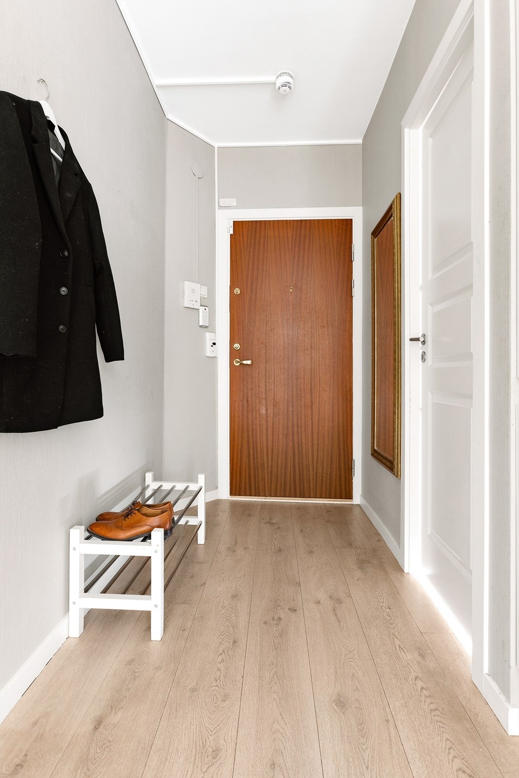 Entré med 1-stavs laminatgulv og lyse veggflater. Leiligheten er tilknyttet felles callinganlegg med automatisk åpner Galleribilde