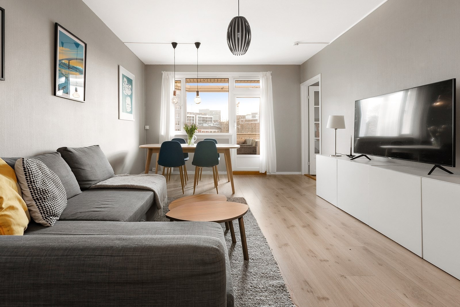 Lys og fin stue med 1-stavs laminatgulv og veggflater malt i duse fargetoner Galleribilde