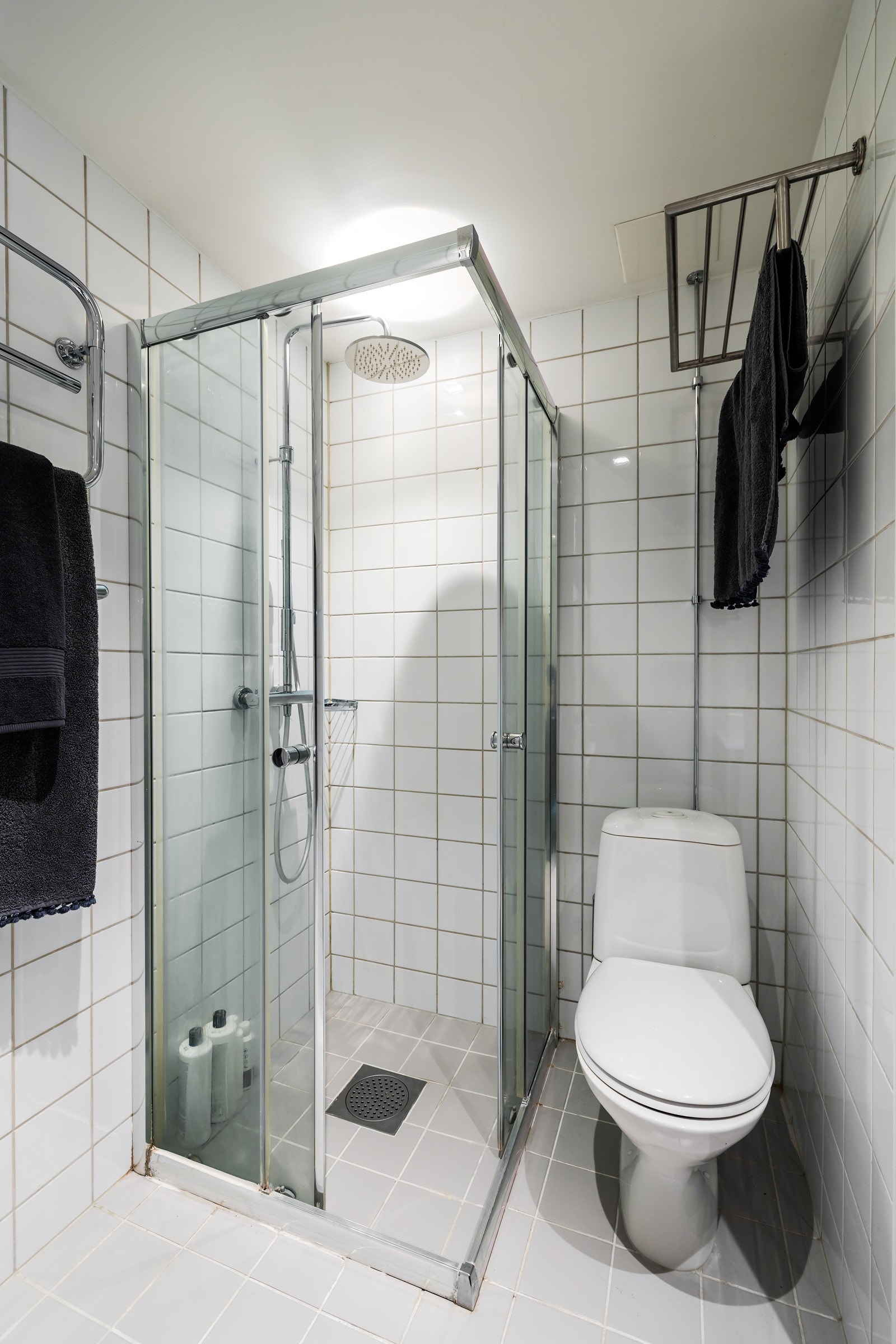 Badet er utstyrt med gulvstående toalett og dusjhjørne med dører i glass Galleribilde