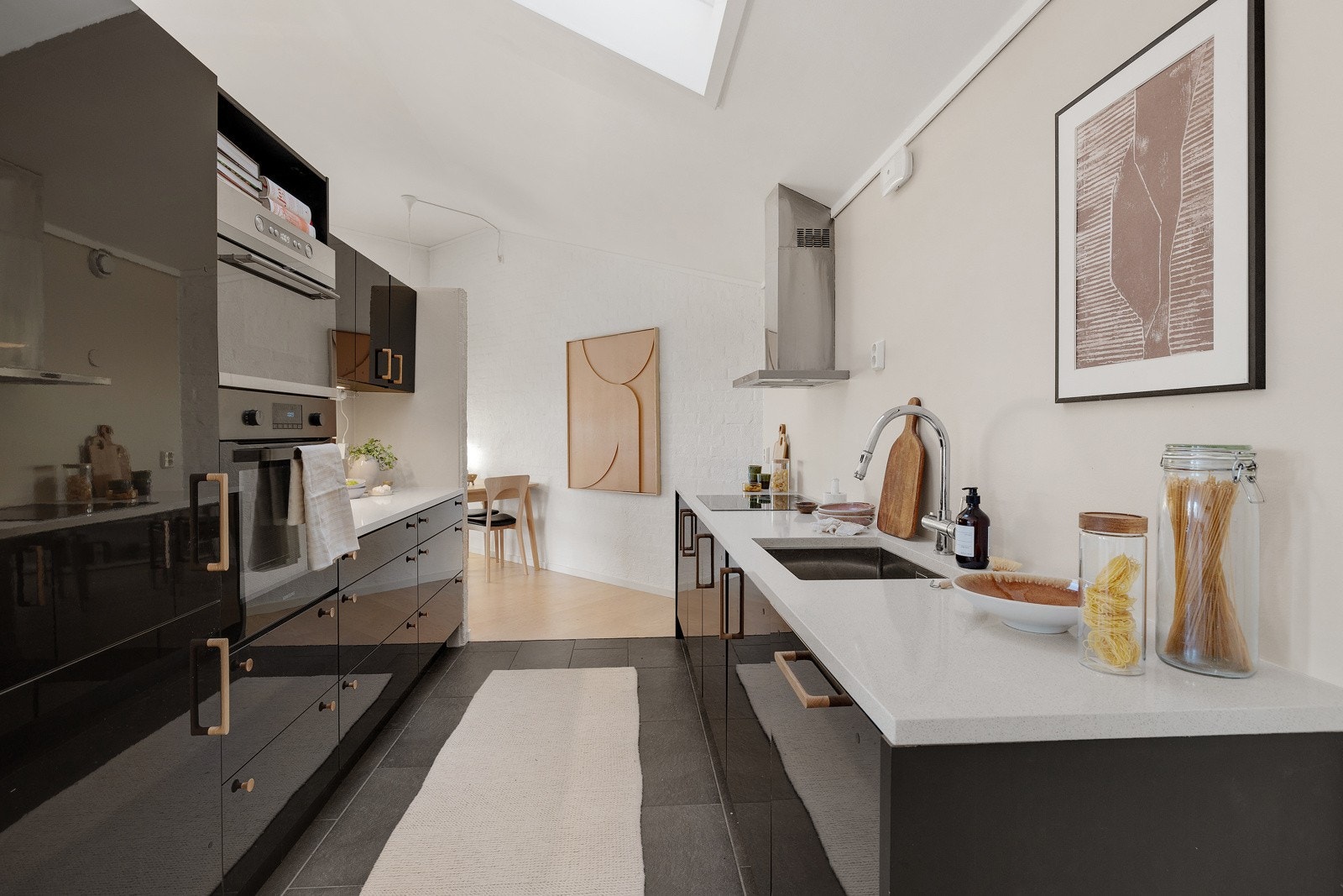 Kjøkkeninnredningen består av fronter i sort utførelse. Benkeplate i kompositt med underlimt oppvaskkum med ett-greps armatur og spylefunksjon fra 2015. Galleribilde