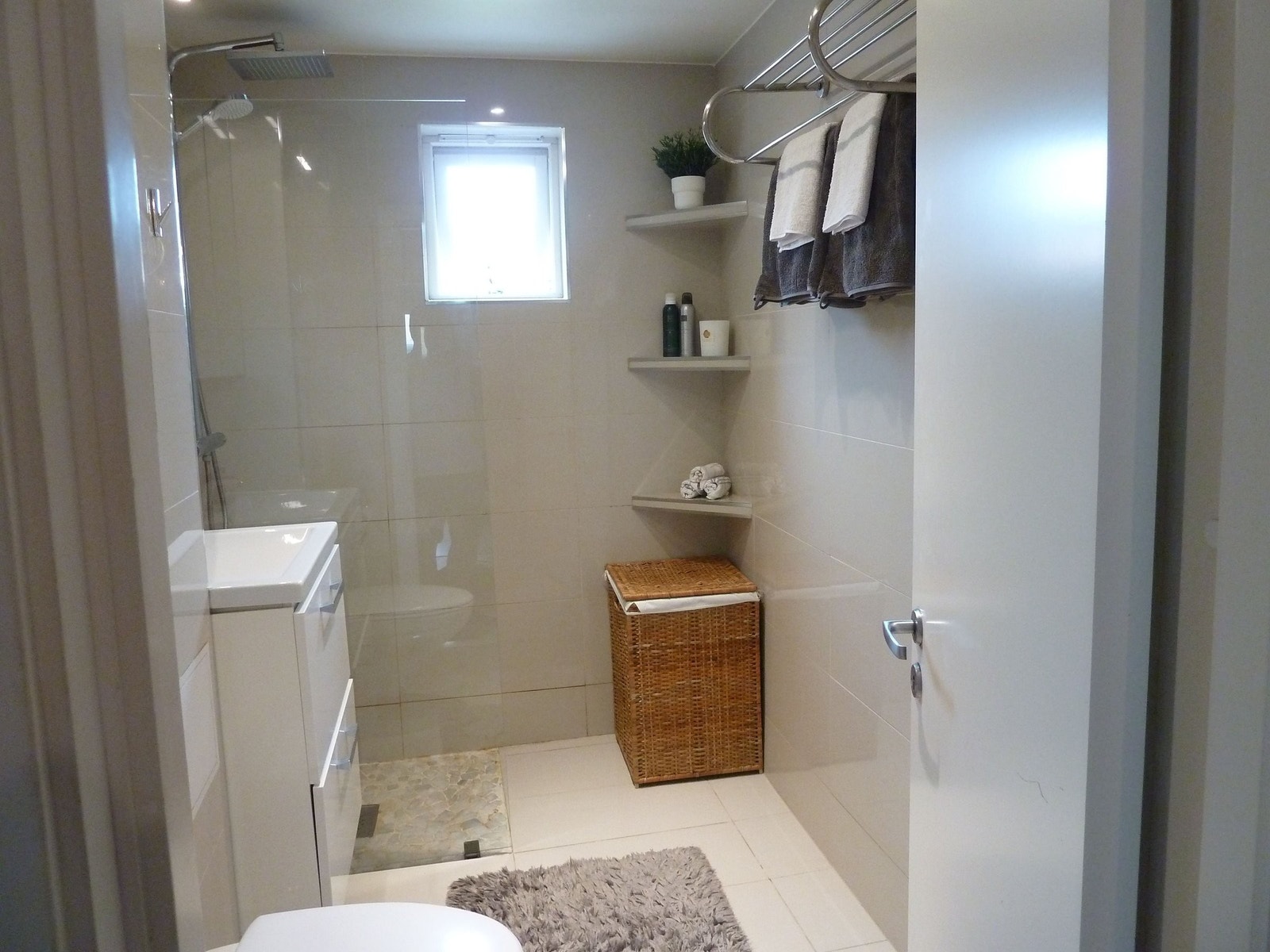 Stort flislagt bad med vannbåren varme i gulv. Lekker innredet med baderomsmøbler , innglasset dusjhjørne og vegghengt toalett. Galleribilde