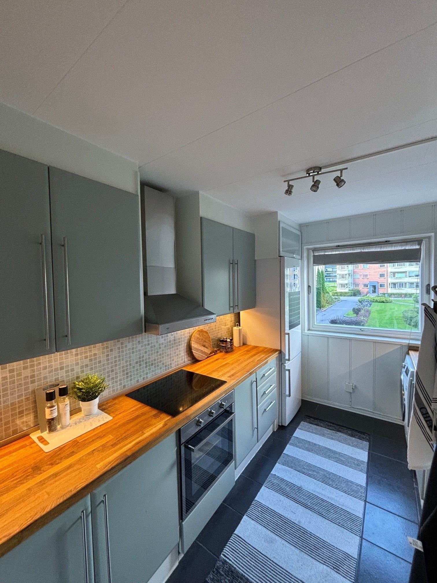 Romslig kjøkken med slette fronter, heltre benkeplate. Medfølgende oppvaskmaskin, ovn, platetopp, kjøleskap og vaskemaskin. Galleribilde