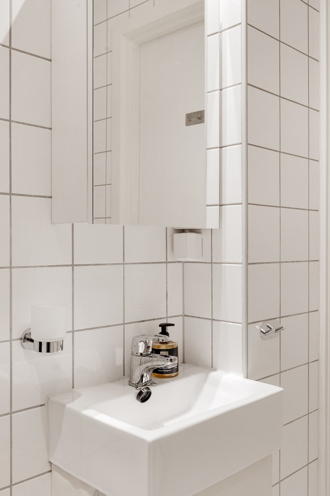 Badet er innredet med vegghengt servantskap, servant med ett-greps armatur, dusjhjørne med dusjdører og vegghengt toalett. Galleribilde