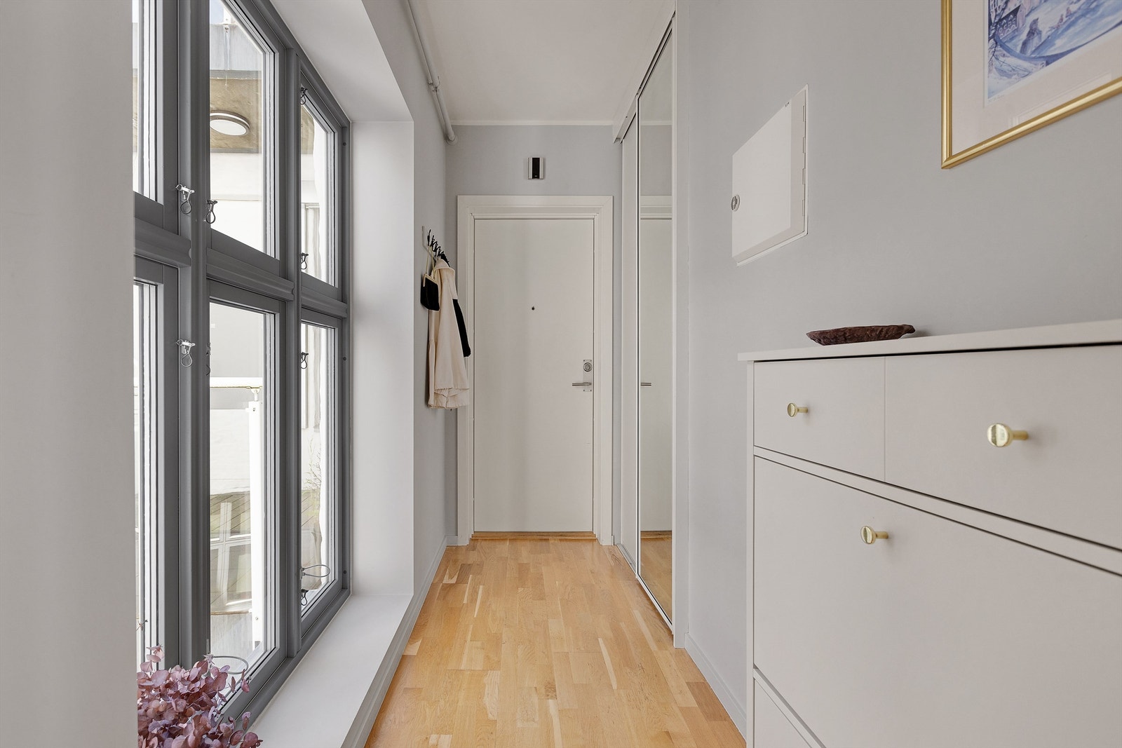 Innbydende entré med god plass til oppbevaring av klær i skyvedørsgarderobe og god plass for å sette fra seg sko. Galleribilde