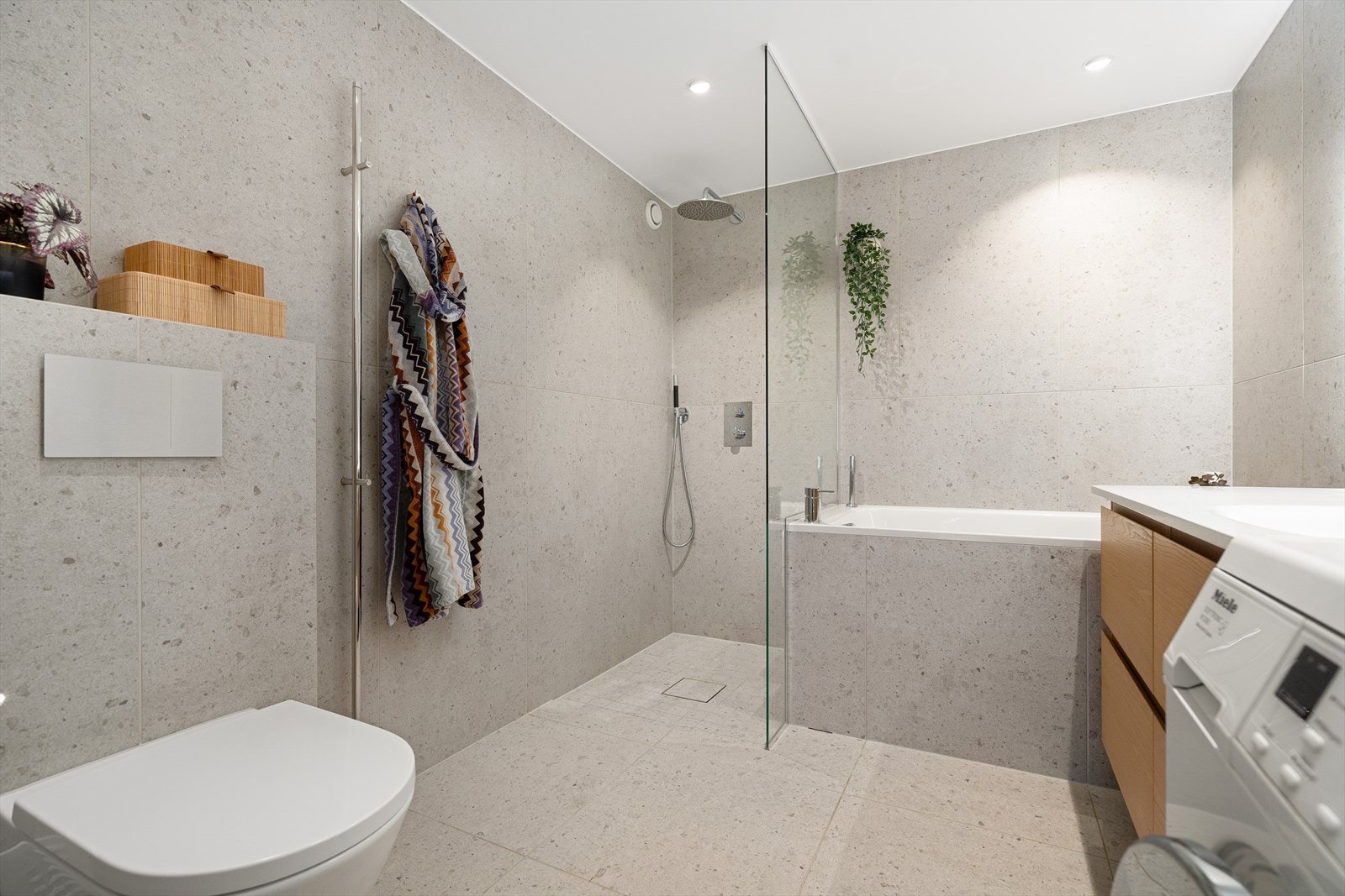 Badet er utstyrt med dusjhjørne med intergret blandebatteri og to dusjhoder, badekar og veggmontert toalett fra Villeroy boch med TwistFlush-spylingen. Galleribilde
