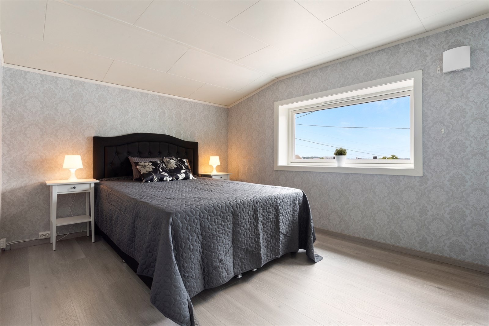 Hovedsoverommet er av god størrelse med plass til dobbeltseng og nattbord på hver side Galleribilde