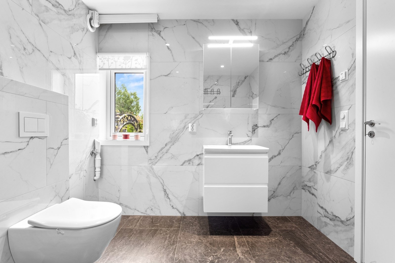 Badet er av god størrelse med fliselagte vegger og malt himling Galleribilde