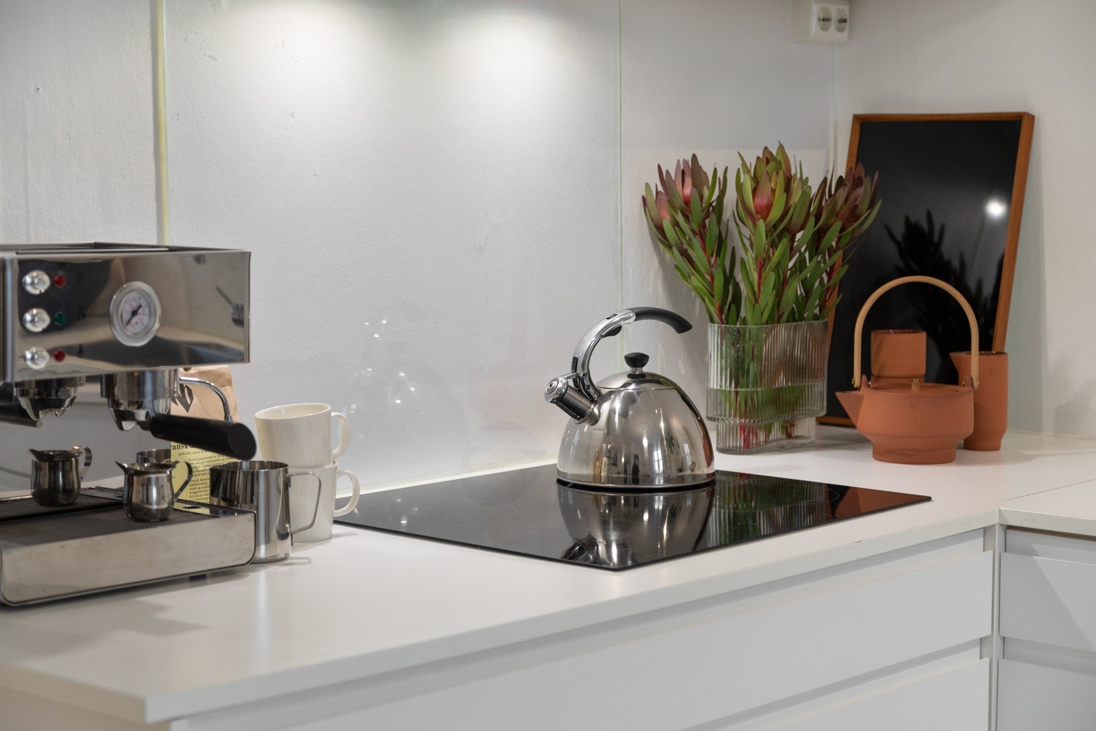 Innredning med Epoq fronter, laminat benkeplate, belysning via lyslist under overskap og glassplate over benkeplaten Galleribilde