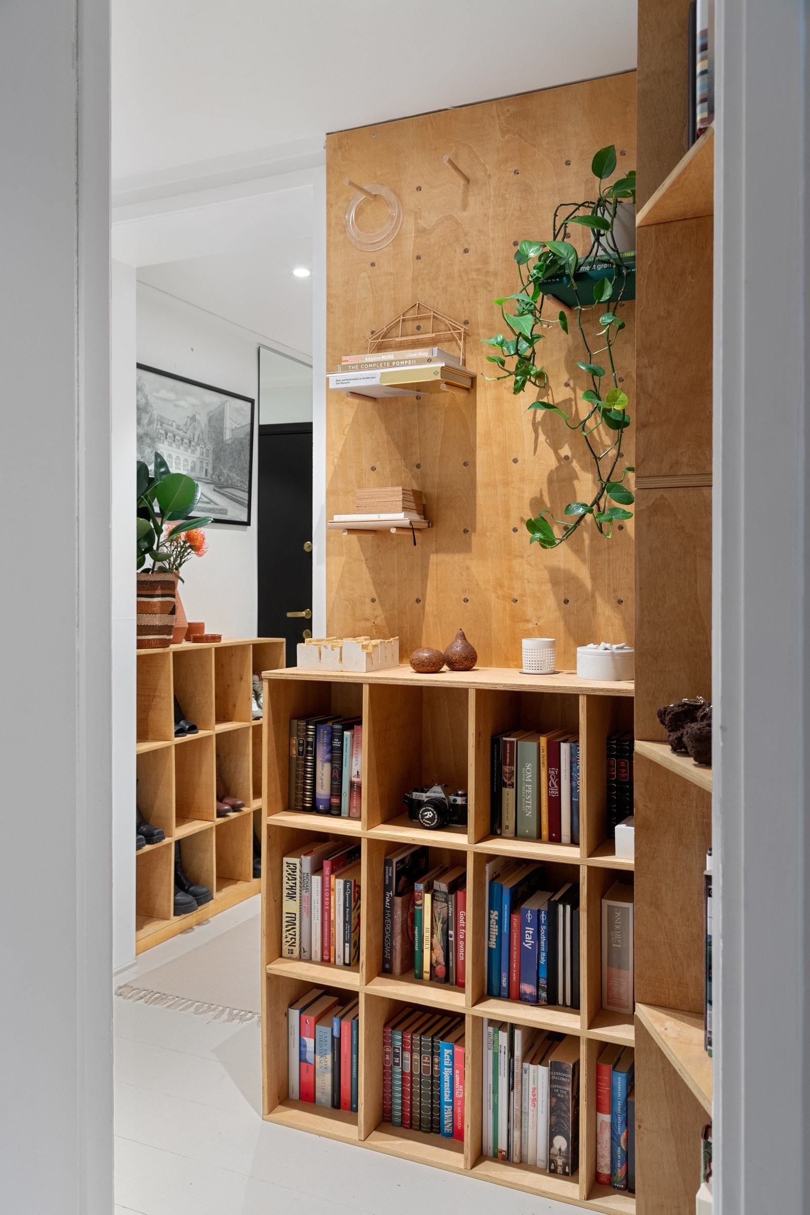 Plassbygd og skreddesydd bokhylle i gangen gir leiligheten et særpreg, og en følelse av et ekstra rom Galleribilde