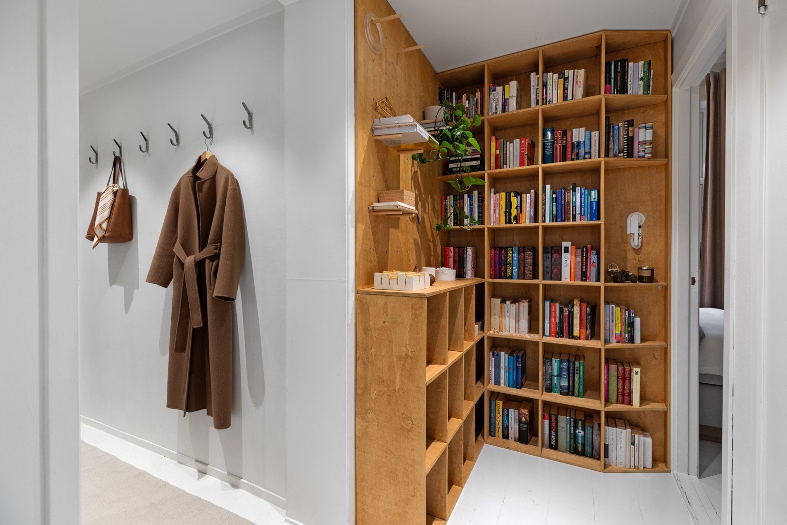 Plassbygd bokhylle fra 2018 i gang og skohylle i entré Galleribilde