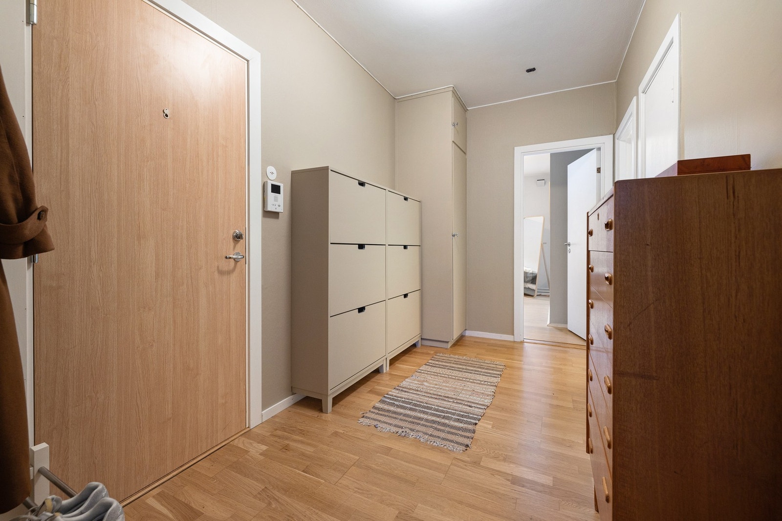 Romslig entré med parkett på gulvet og moderne fargevalg som skaper et tidløst uttrykk. Galleribilde