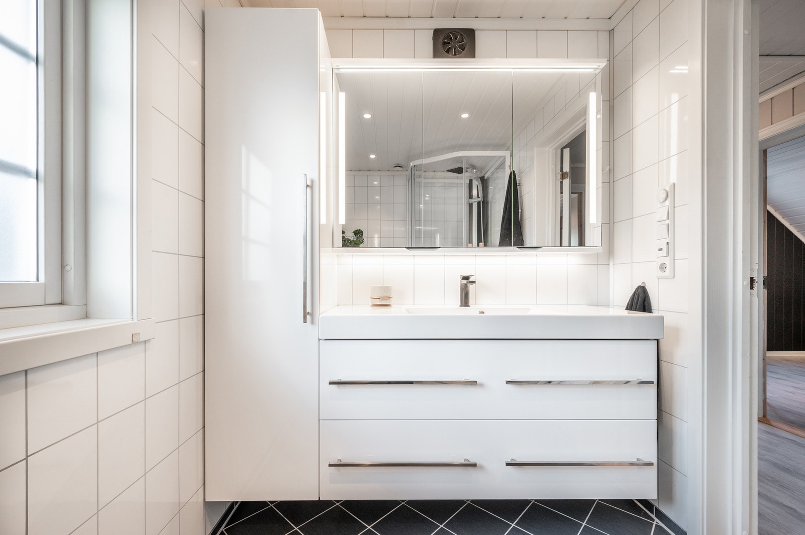 Rommet er innredet med servantinnredning, speilskaper, dusjkabinett og toalett. Galleribilde