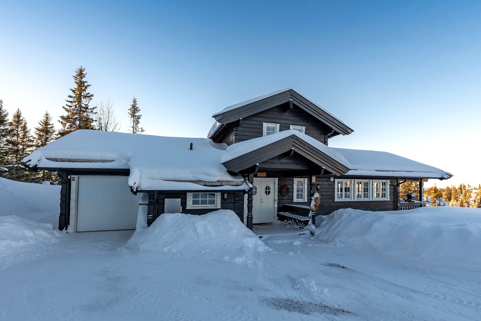 Frittstående hytte med inntilbygd garasje og bod og god plass til parkering på egen gårdsplass. Galleribilde