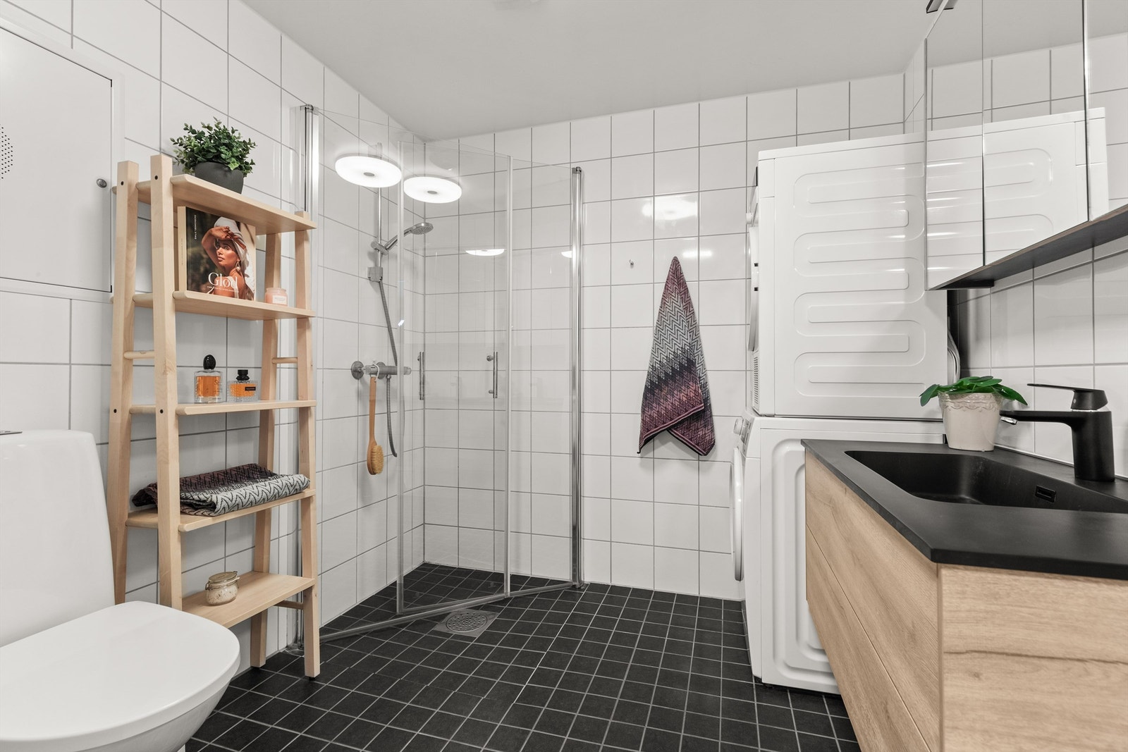 Videre har badet dusjhjørne med svingbare glassdører og vegghengt klosett Galleribilde