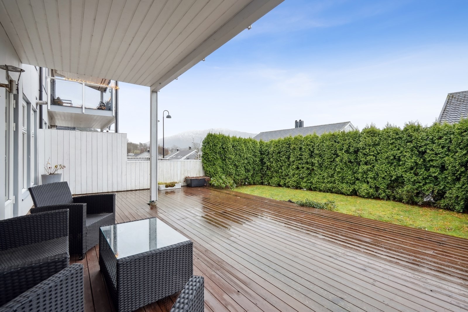 Uteplassen - tillaget med treterrasse, plenareal og grønn hekk for skjerming Galleribilde