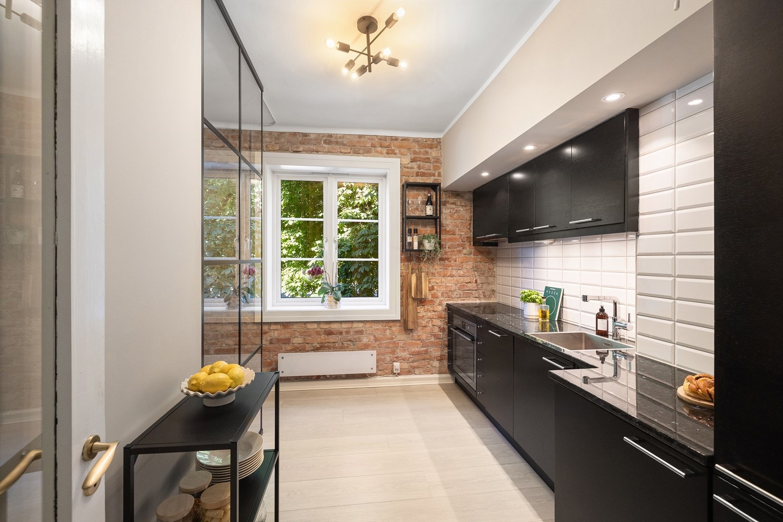 Tidsriktig, stilrent og separat kjøkken fra 2017. Innredning med glatte, finerte fronter, fliser på vegg over kjøkkenbenk og benkeplate i stein. Galleribilde