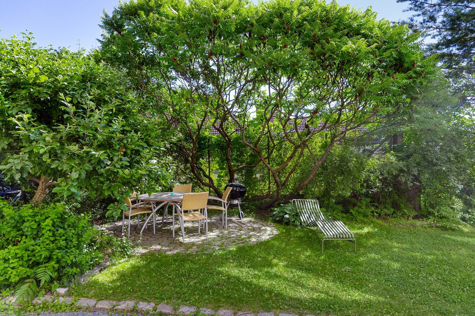 Idyllisk bakhage med sittegrupper, beplanting og koselig internvei. Galleribilde