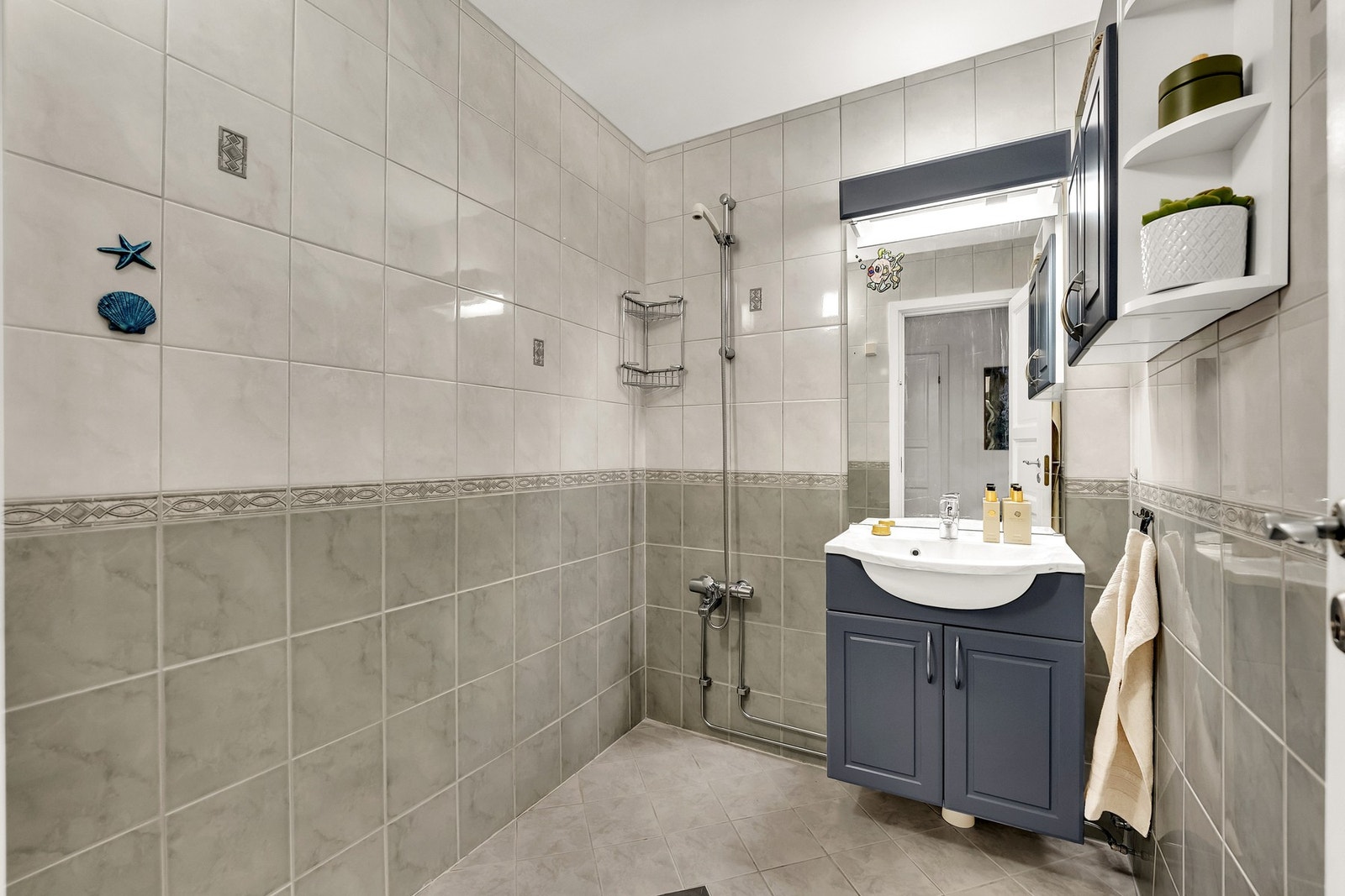 Baderomsinnredningen er bestående av vegghengt servantskap med heldekkende servant og ett-greps armatur. Galleribilde