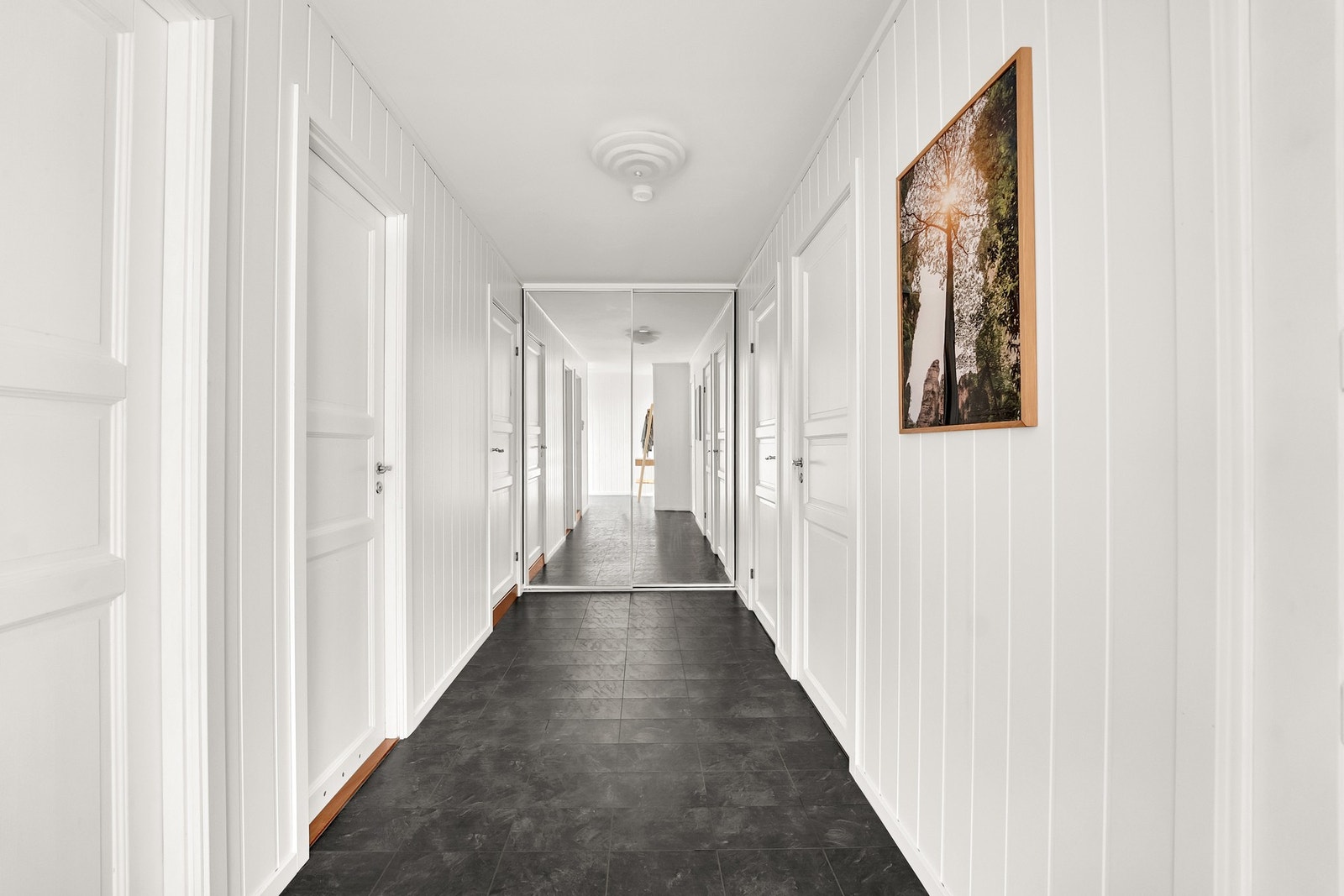 Lys og romslig entré med god plass til oppbevaring i skyvedørsgarderobe. Galleribilde