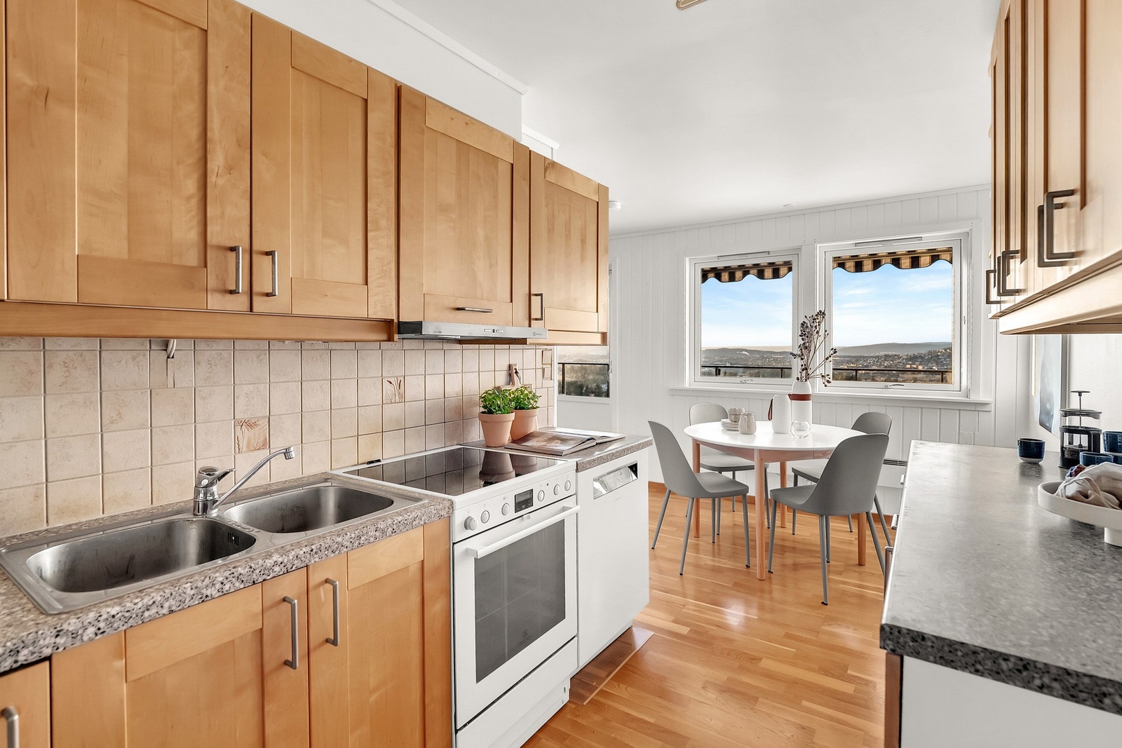 Nedfelt oppvaskkum med ett -greps armatur og flislagt mellom kjøkkenbenk og overskap. Galleribilde