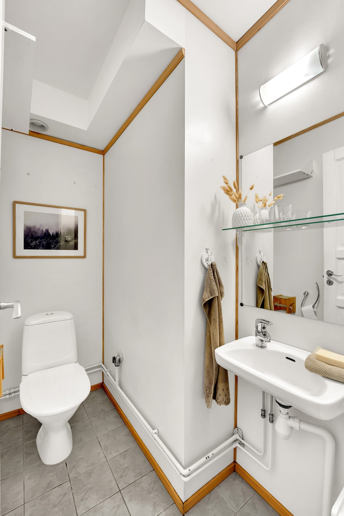 Flislagt toalettrom med malte veggflater, gulvmontert toalett og servant. Galleribilde