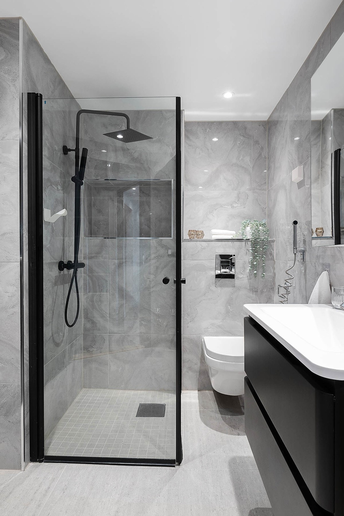 Badet består av vegghengt baderomsinnredning med glatte mørke fronter. Badet har opplegg for vaskemaskin Galleribilde