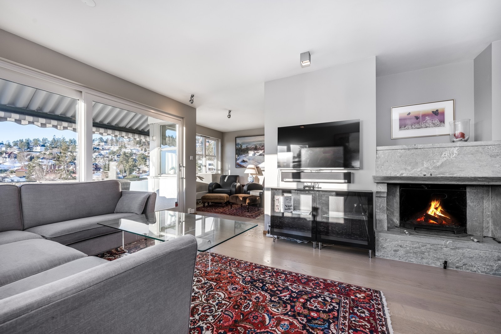 Lys og fin stue med flott ildsted og store vinduersflater Galleribilde