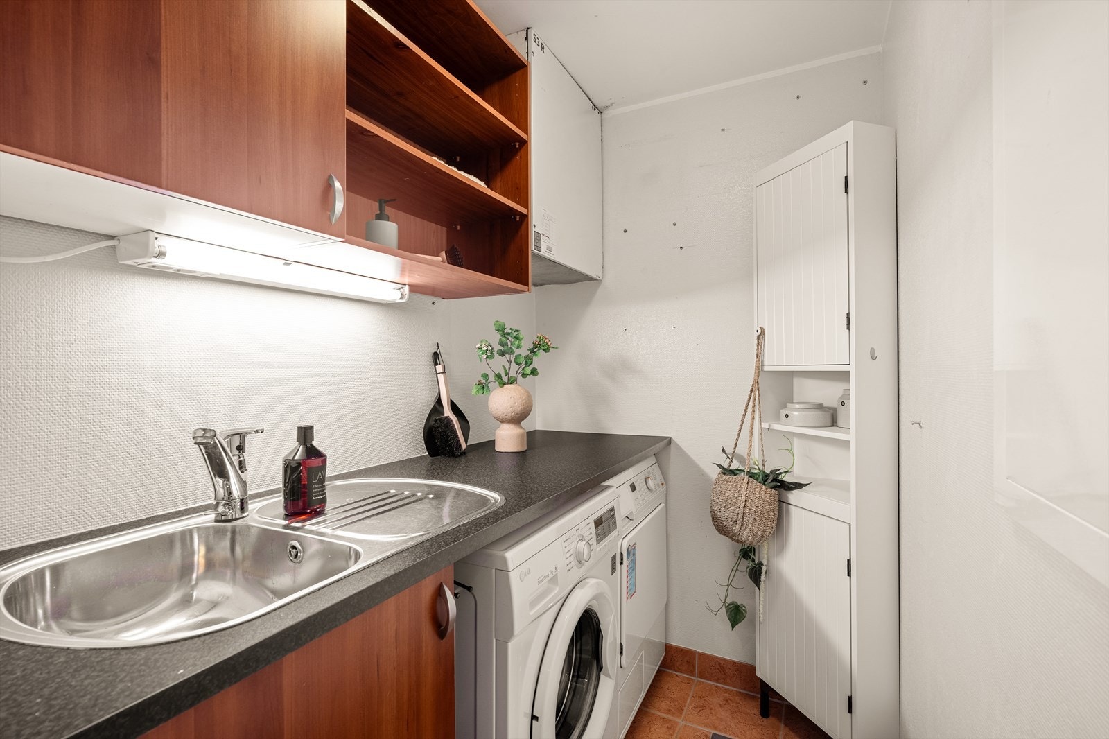 Vaskerommet på 2,5 m² er praktisk innredet med flislagt gulv, sokkelflis og malte strievegger. Galleribilde