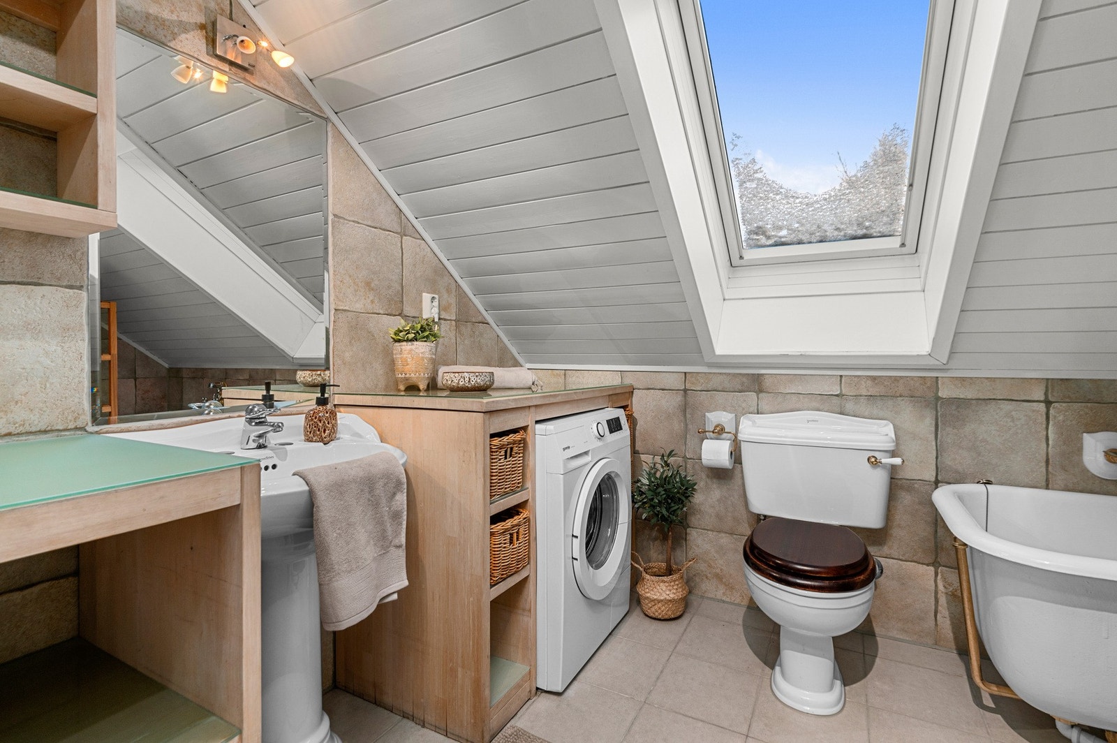 Badet er praktisk og delikat innredet med plass til både oppbevaring og vaskemaskin. Galleribilde