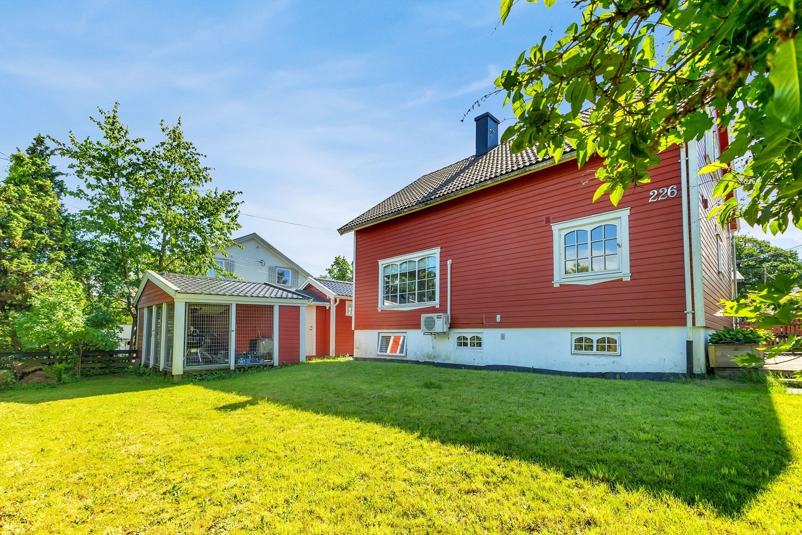 En romslig enebolig, pent opparbeidet med gressplen og diverse beplantning Galleribilde