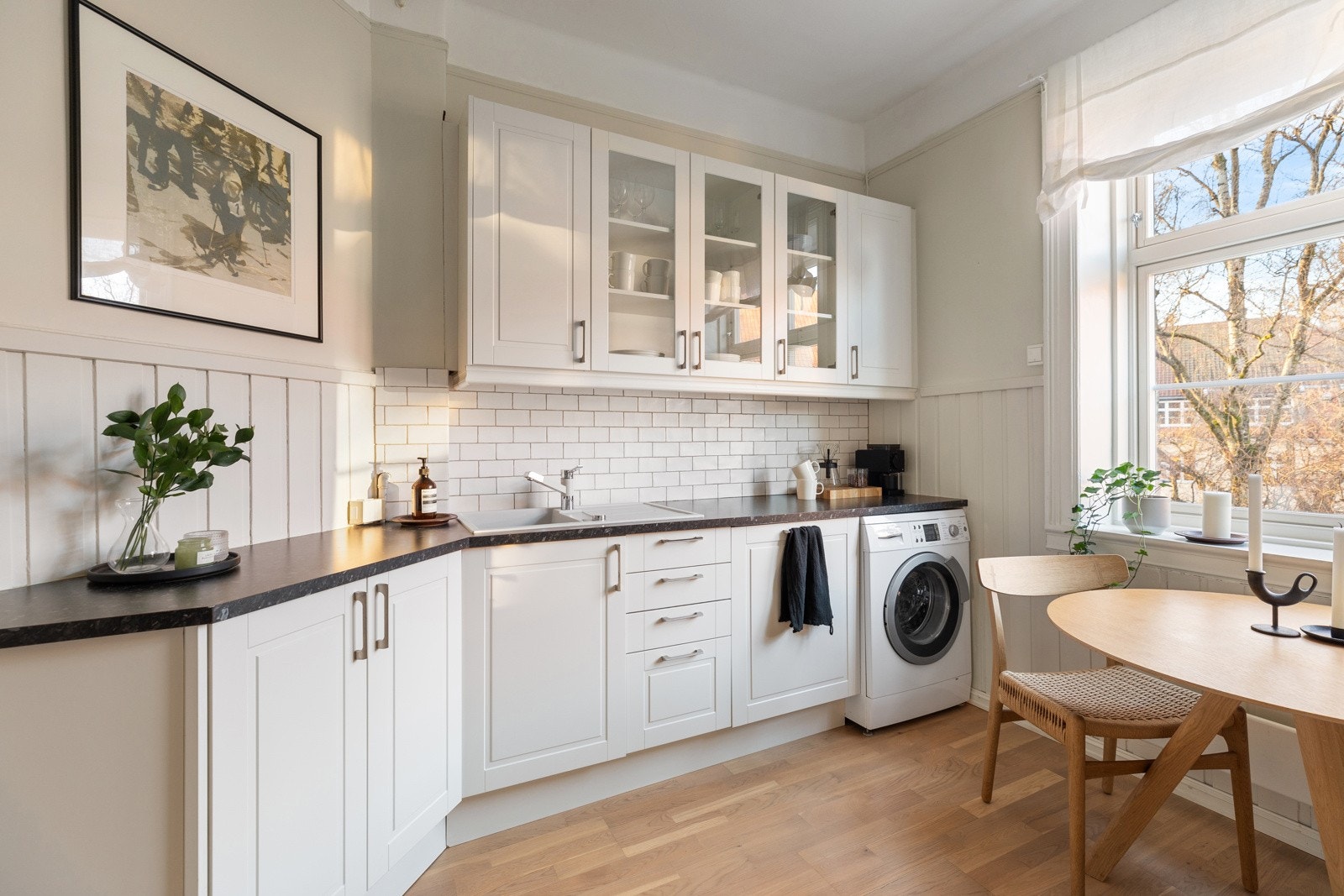 Kjøkkeninnredning er utført med glatte fronter i lys utførelse fra Norema, og byr på integrerte hvitevarer som komfyr, platetopp, oppvaskmaskin og kjøle- og fryseskap Galleribilde