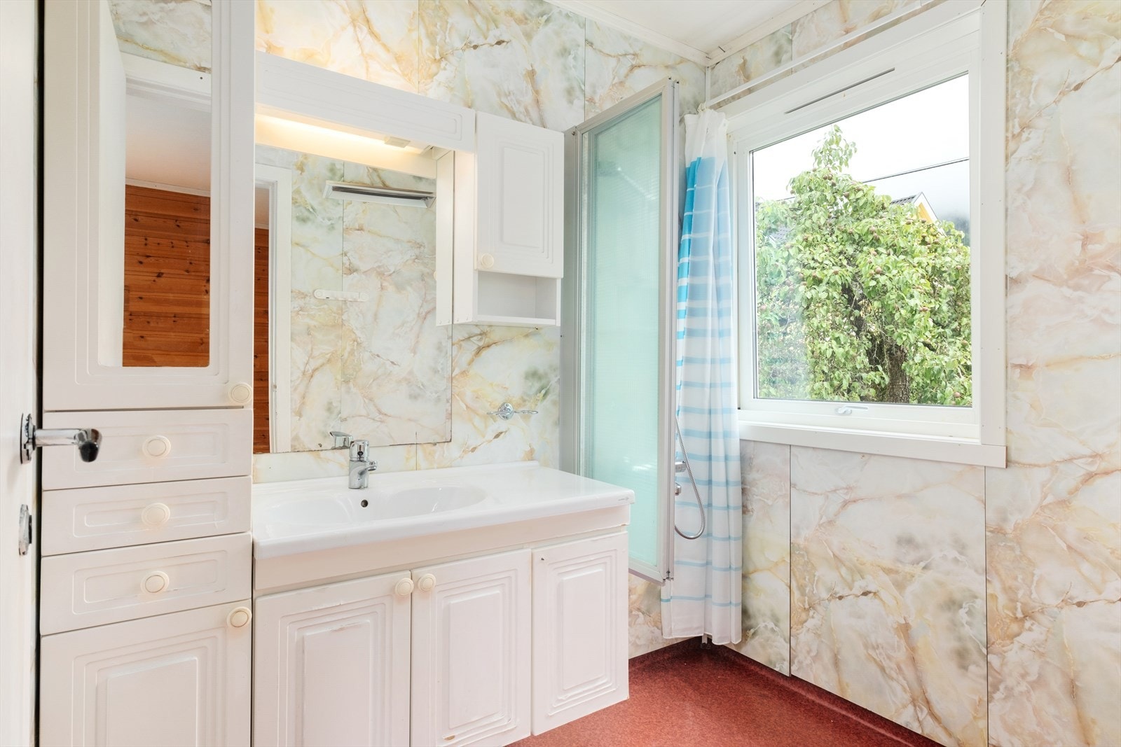 Badet har baderomsplater på vegg og belegg på golv. Det er innreia med kvit baderomsmøbel med servant og dusj. Det er eit lite toalettrom i tilknyting med bad. Galleribilde