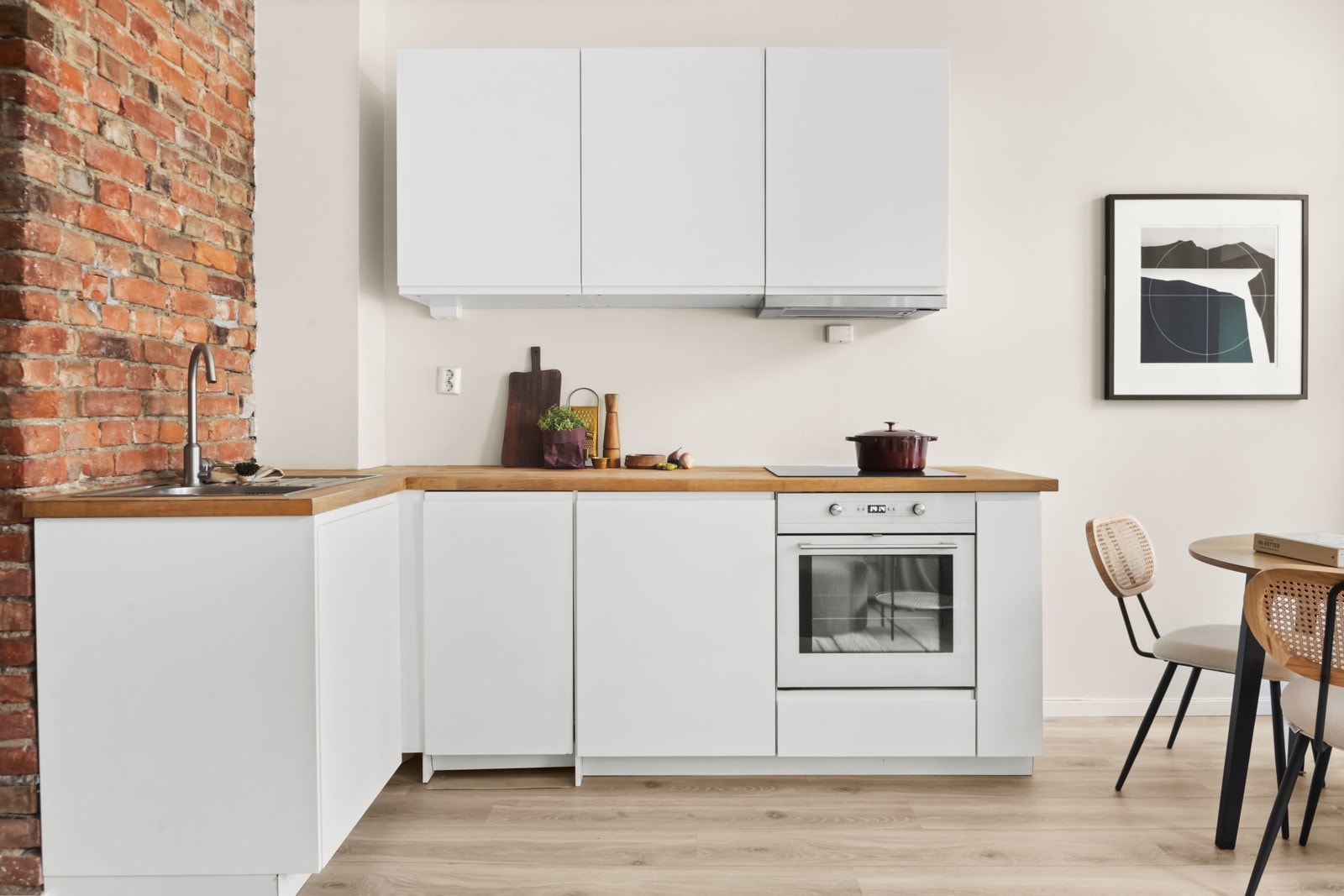 Stilrent kjøkken fra 2016 med hvit, glatt innredning og heltre benkeplate. Galleribilde